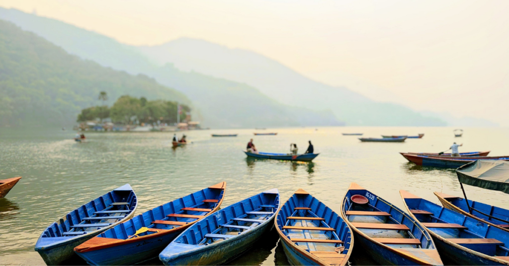 Traditional colorful boats on Phewa Lake with Annapurna mountain range in Pokhara Nepal